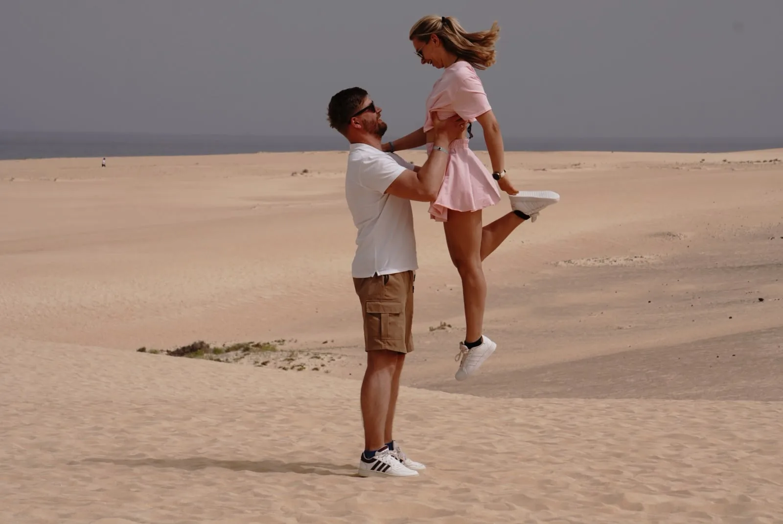 Pareja celebrando entre las dunas frente al mar